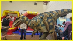 A realistic open legs raptor costume for UK party hire dinosaur party kids party